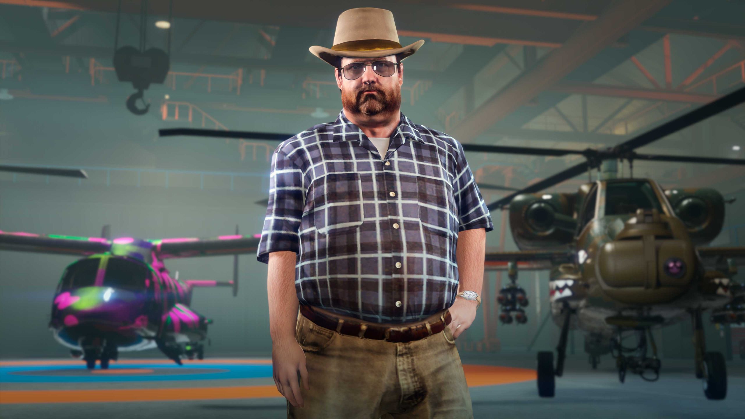 Rooster McCraw stands inside a hangar nearby weaponized aircraft.