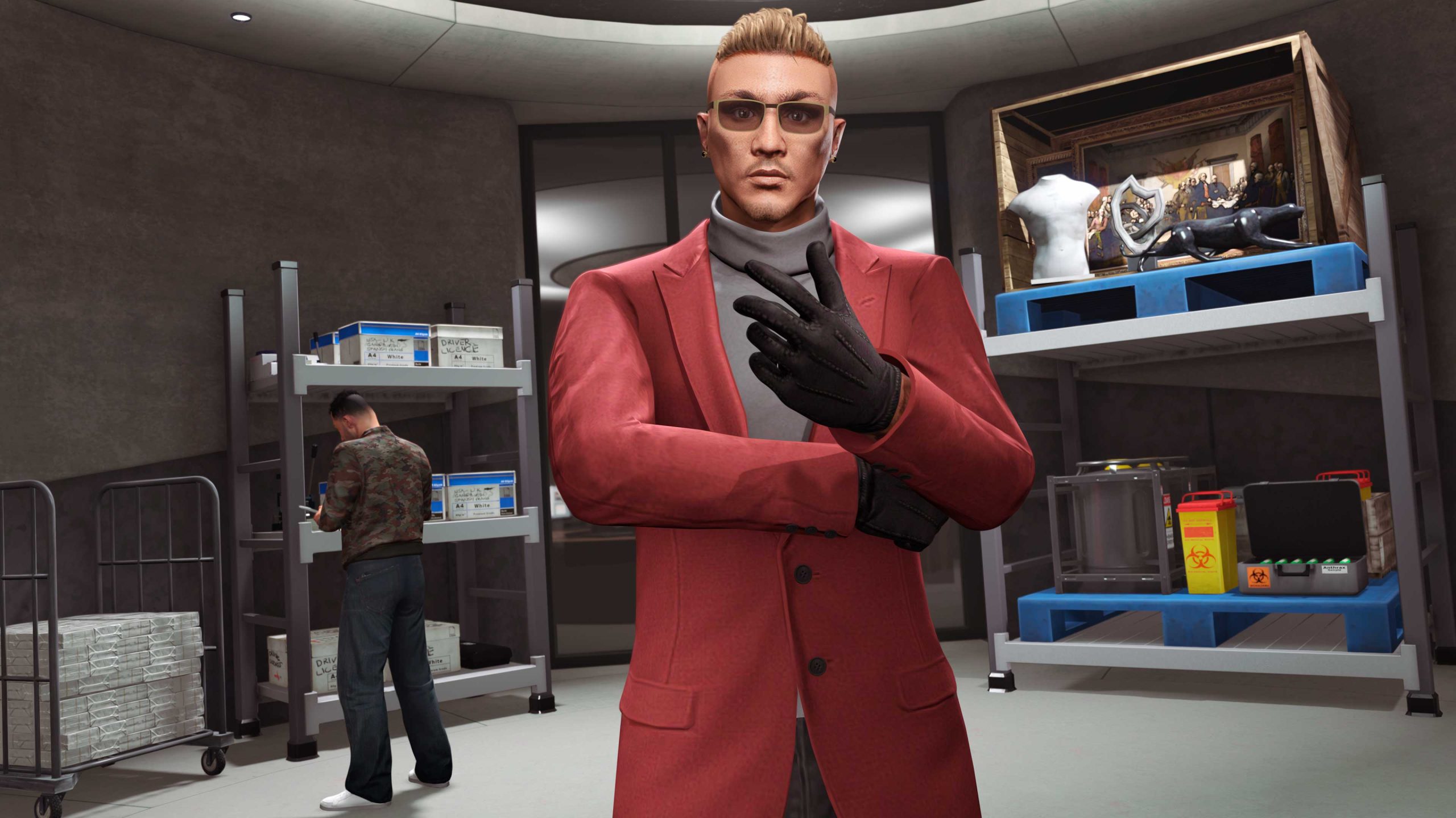 Inside a storage room, A GTA Online character looks to the camera as someone takes stock in the background. 