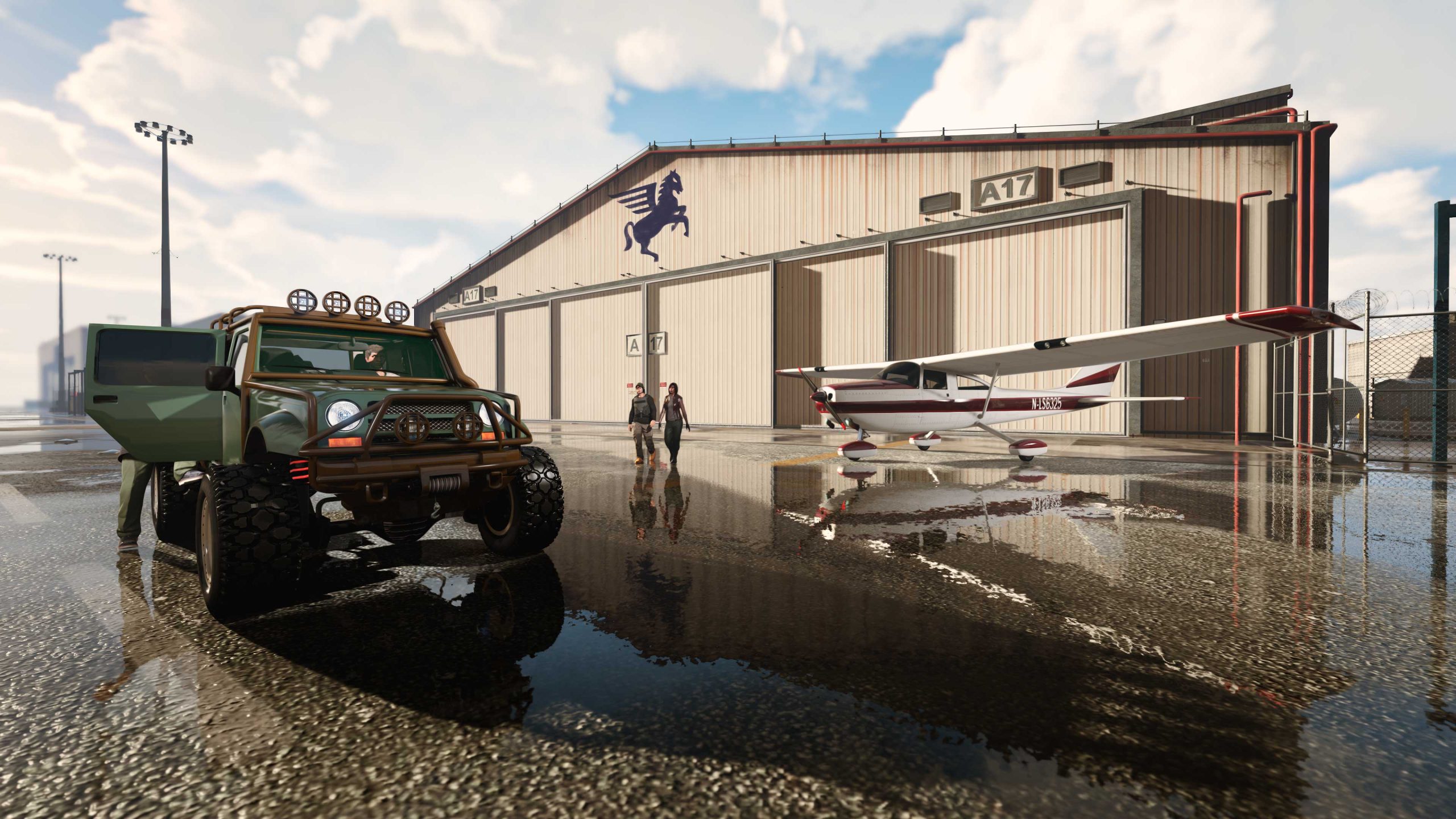 An off-road car and a plane outside of a hangar. 