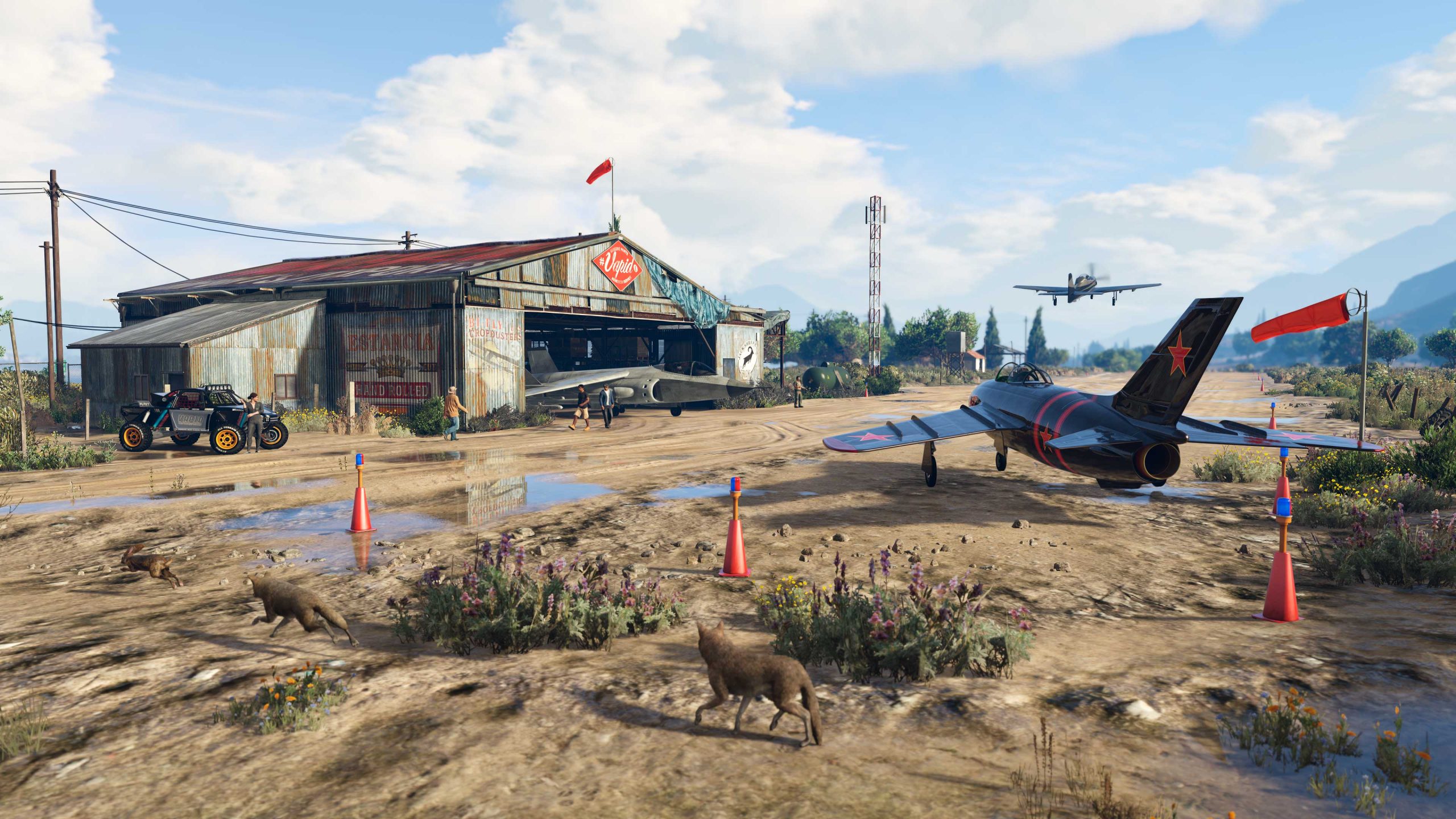 Planes prepare for takeoff at the McKenzie Field Hangar with an off-road vehicle and jet parked at the hangar bay. A coyote walks through the scene. 